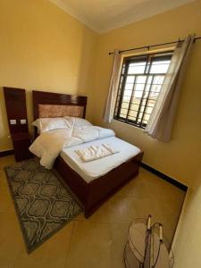NjombeGetaway bnb - Njombe的一间卧室设有一张床和一个窗口