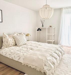 ErmatingenHaus am Bodensee mit Sicht - Stilvoller Luxus的白色卧室设有一张大床和一盏灯。