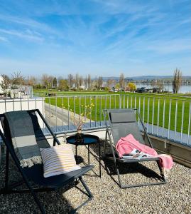 ErmatingenHaus am Bodensee mit Sicht - Stilvoller Luxus的阳台上摆放了几把椅子和一张桌子