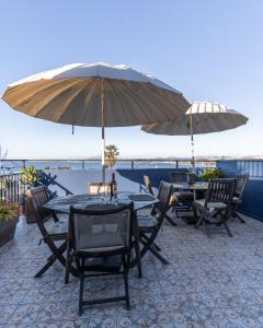 瓦尔帕莱索Val Paradou - ex - Casa Magnolia的庭院里配有两张桌子和椅子以及遮阳伞