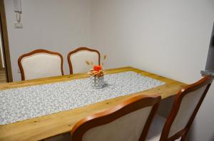 ČrničeApartmaji Tanto Malovše的一张桌子,上面有四把椅子和一个花瓶
