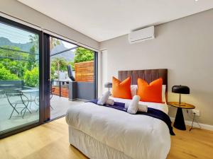 开普敦Luxurious Family home in Newlands with Pool的一间卧室配有一张带橙色枕头的大床