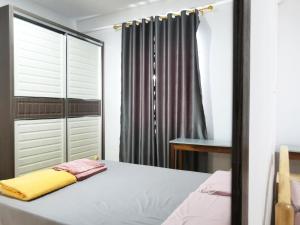 Kota Samarahanpen kyu house1的一间卧室配有一张床和一个衣柜