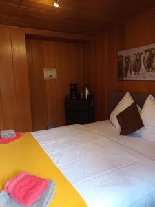 龙疆Elliotts Bed & Bar的一间卧室配有带白色床单和粉红色毛巾的床