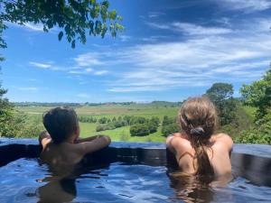 霍维克Little Fields Country House and Cottages的坐在热水浴缸中的男孩和女孩