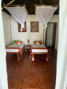 nosykombafafa的一间设有两张床和窗帘的墙壁客房