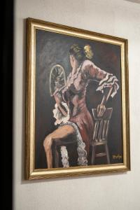 斯科普里Hotel Restaurant Domestika的坐在椅子上的女人的画