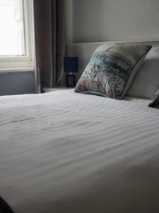 布莱克浦The Melville Hotel - Central Location的一张带枕头和窗户的白色床