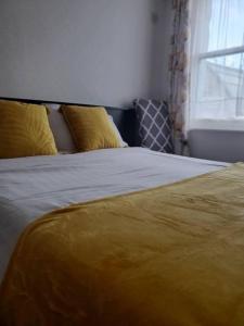 布莱克浦The Melville Hotel - Central Location的一张带黄色毯子和窗户的床