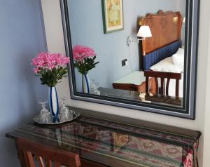 瓦雷泽La Collina since 2008 NO SMOKING B&B的一张桌子上的镜子,在房间里放着鲜花