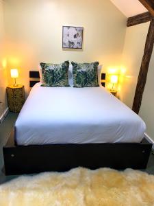 普罗温斯敦Lotus Provincetown的一间卧室配有一张带两盏灯的大型白色床。