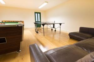 巴克斯顿Swifts Retreat的客厅配有乒乓球桌和沙发
