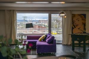 科布伦茨Pop Art Loft über den Dächern von Koblenz的客厅配有紫色沙发和大窗户