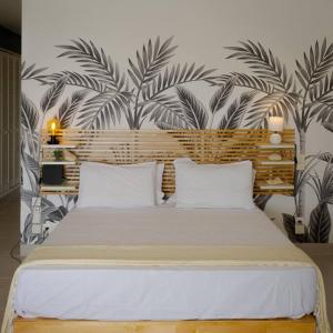 Saint MartinStudio magnifique vue sur mer的一间卧室配有一张带热带壁纸的大床