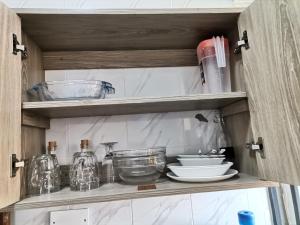 蒙巴萨Millan Homes的碗柜,上面有餐具和其他厨房用品