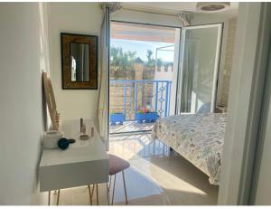 科尔多瓦Casa Muralla del Alcazar Viejo的一间带一张床和一张书桌的卧室以及一个阳台