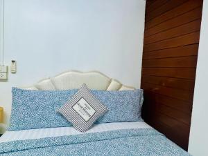 曼谷Ree Guesthouse的一间卧室配有一张带蓝色和白色枕头的床