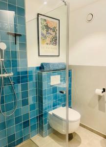 马夸特施泰因Traumhafte Ferienwohnung in historischem Brandmanngut的蓝色瓷砖浴室设有卫生间和淋浴。