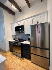 新奥尔良Chic Two-Bedroom Apartment on Camp St, New Orleans的厨房配有不锈钢冰箱和白色橱柜