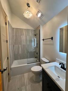 新奥尔良Chic Two-Bedroom Apartment on Camp St, New Orleans的浴室配有卫生间、浴缸和水槽。