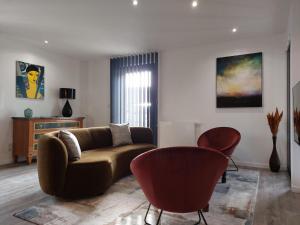 亚眠Urbs Amiens Sud的客厅配有沙发和两把椅子