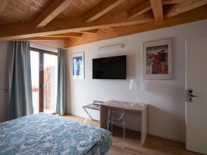 梅纳焦Foresteria Lago di Como的一间卧室配有一张床、一张书桌和一台电视