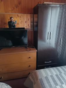 蒙特港Residencial familiar的一个人在卧室里拍电视的照片