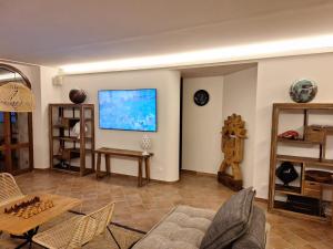 乌尔比诺laCelletta Country House的客厅配有沙发和墙上的电视