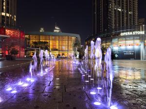 迪拜The Address Residences Dubai Opera , Full Burj Khalifa View , Luxurious 2BR的夜间在建筑物前的喷泉