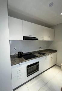 恩卡纳西翁Departamento de 1 ambiente的白色的厨房配有水槽和微波炉