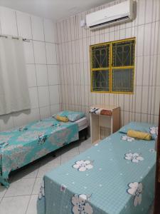 马塞约Casa Eco Via Norte - MCZ的客房设有两张床、一张桌子和一扇窗户。