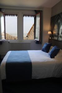 圣米歇尔山特拉斯布拉德酒店的一间卧室设有一张大床和两个窗户