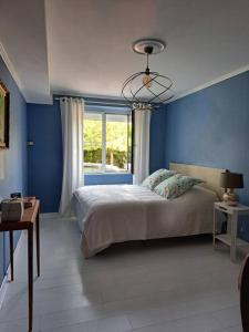La Petite-BoissièreGîte Marguerite - Au coeur de la campagne的蓝色的卧室设有床和窗户