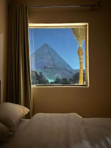 开罗Glamour Pyramids Hotel的从卧室的窗户可欣赏到金字塔的景色