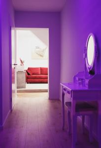 萨格勒布Villa Vino & Grad的紫色的客房配有红色的沙发和镜子
