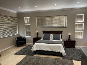 布隆方丹Grants Hill Inn的一间卧室配有一张床、一把椅子和窗户。