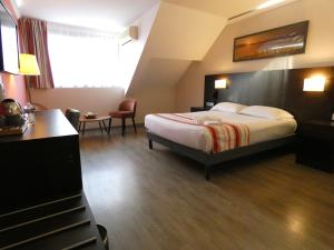 里摩日Hotel Be Guest Limoges Sud - Complexe BG的配有一张床和一张书桌的酒店客房