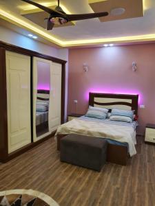 卢克索Cosy appartment in city的一间卧室配有一张紫色照明的大床