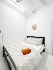 八打灵再也Homestay Dsunway的白色卧室配有带橙色枕头的床