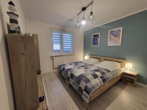 格丁尼亚Apartament Nad Klifem SEA VIEW的一间卧室配有一张带 ⁇ 子毯子的床