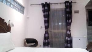 布拉柴维尔Villa takamelouer immo的卧室配有黑色和白色的浴帘