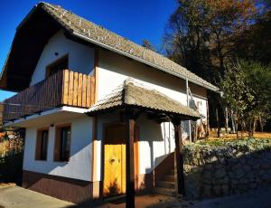 新梅斯托Hiška sončni hrib.的一座带木门和阳台的小房子