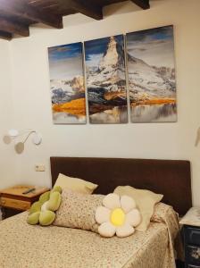 塞尔塞迪利亚Casita roja的卧室配有一张壁挂着四幅画作的床