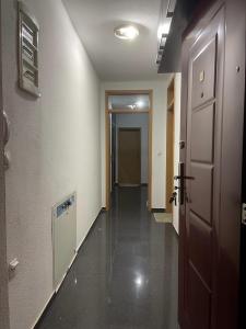 Kosovo PoljeErion’s apartament的一条空的走廊,有门,走廊有丝丝绸