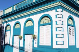 瓜亚马City Dreams Cozy Loft in Guayama Great Location的蓝白色的建筑,设有窗户和门