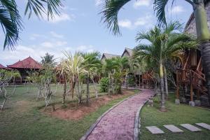 蓝梦岛Abian Huts Dream Beach Lembongan的棕榈树度假村前的走道