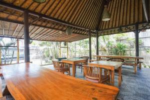 蓝梦岛Abian Huts Dream Beach Lembongan的用餐区配有木桌和椅子