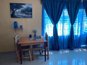 KibuyeSpa Shallum的餐桌、椅子和蓝色窗帘