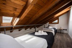 莱科La Casa del Sarto - Rooms and Apartments的配有木天花板的客房设有两张床。