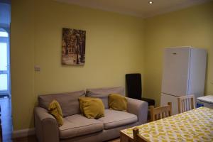 伦敦Three Bedroom House Lancaster Road的客厅配有带黄色枕头的沙发